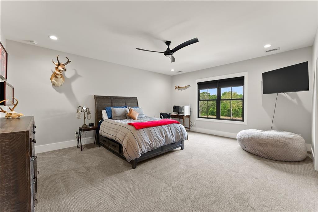 373 Fortress Way Jefferson, GA 30549 - Photo 71 of 118 a spacious bedroom with a bed and a flat screen television
