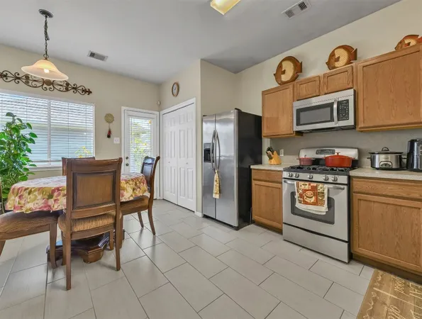 a kitchen with stainless steel appliances granite countertop a refrigerator and a stove top oven