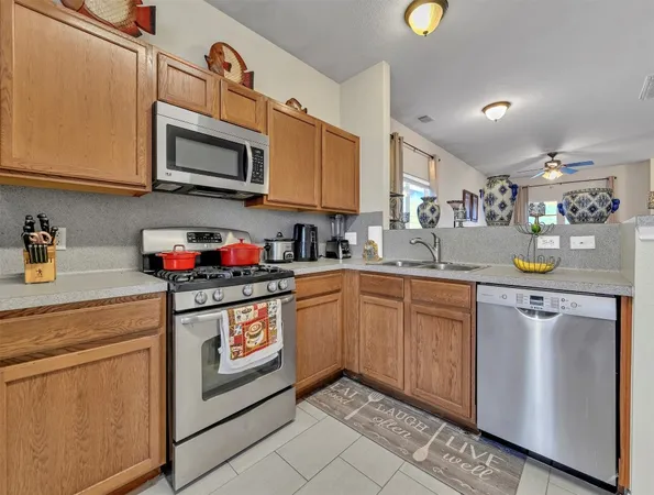 a kitchen with stainless steel appliances granite countertop a sink a stove cabinets and a microwave