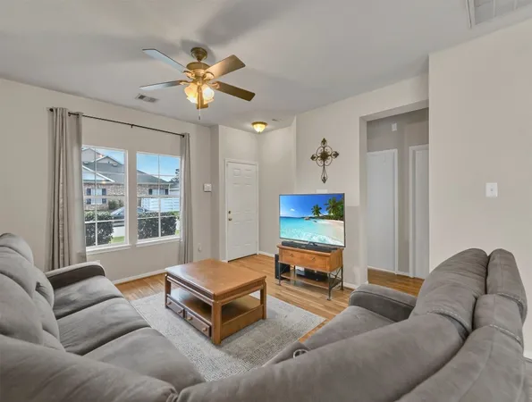a living room with furniture a flat screen tv and a large window