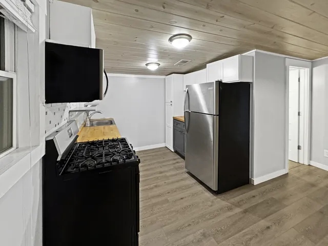 a kitchen with a refrigerator and a flat screen tv