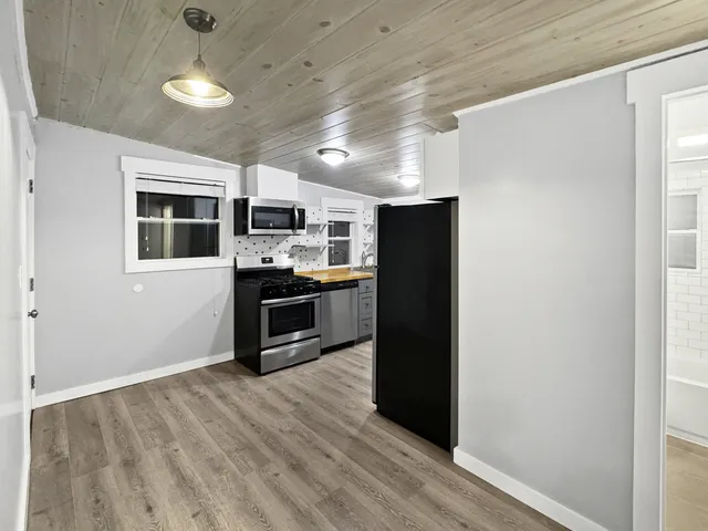 a kitchen with stainless steel appliances granite countertop a refrigerator and a stove top oven