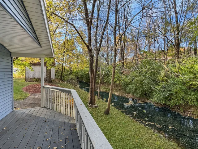 a view of balcony with wooden floor and fence