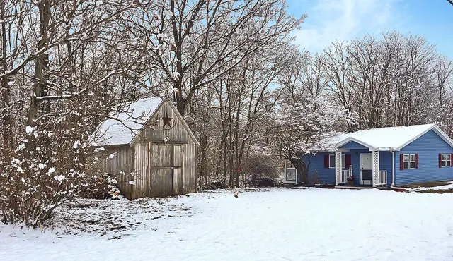 a front view of a house with a yard covered in snow