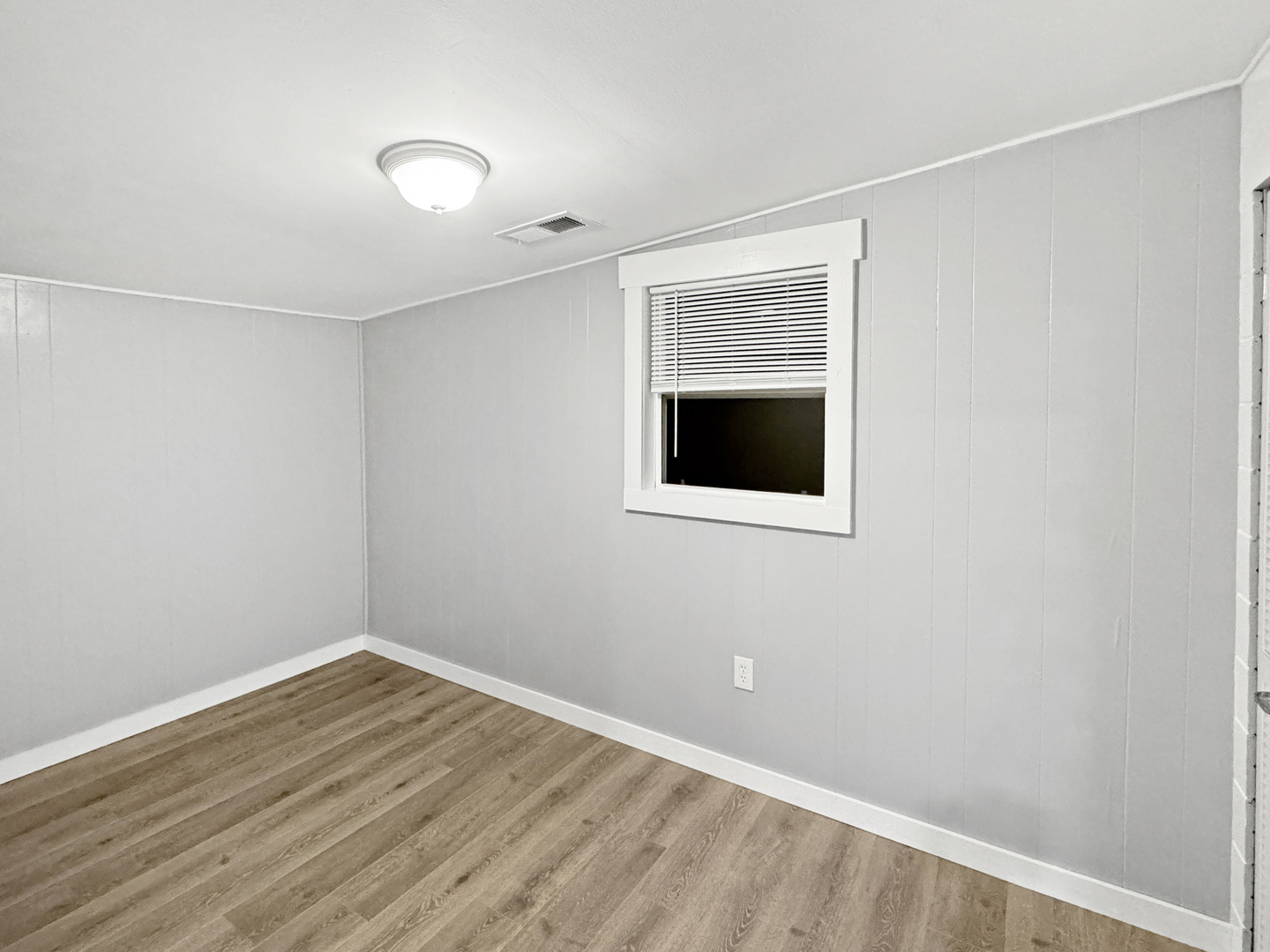 200 East Grove Street Utica, IL 61373 - Photo 8 of 41 a view of an empty room with wooden floor and a window