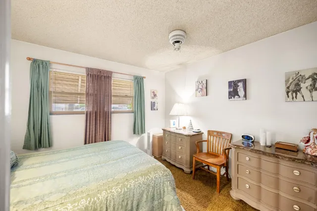 a bedroom with a bed and large windows