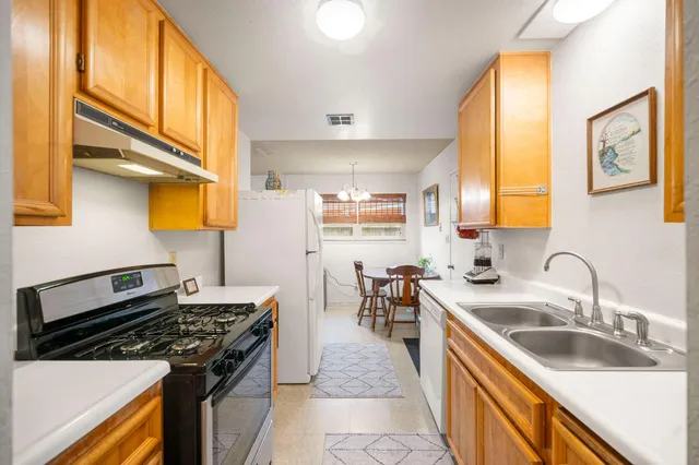 a kitchen with stainless steel appliances a stove a sink and a microwave