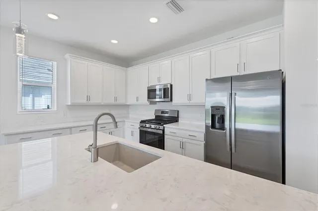 a kitchen with a refrigerator sink and stainless steel appliances