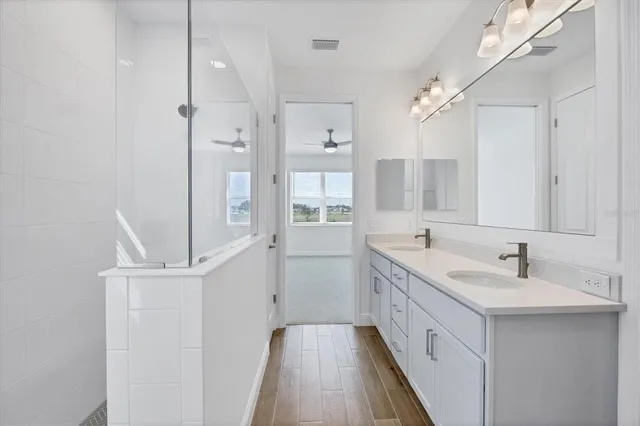 a bathroom with a double vanity sink a mirror and a bathtub