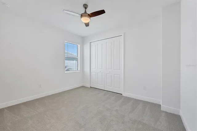 an empty room with a window and a fan