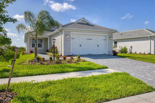 a front view of a house with a garden and plants