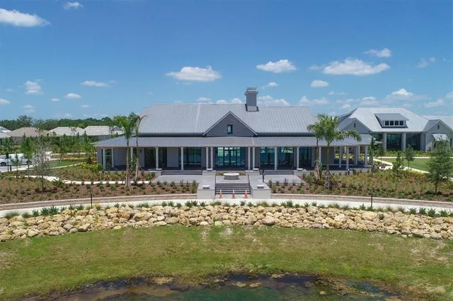 a view of a house with a yard and palm trees