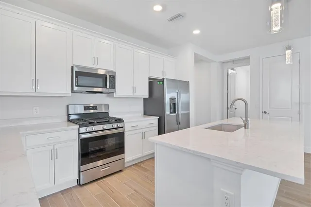 a kitchen with stainless steel appliances granite countertop a stove a refrigerator and a microwave