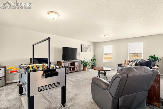 a living room with furniture a flat screen tv and a window