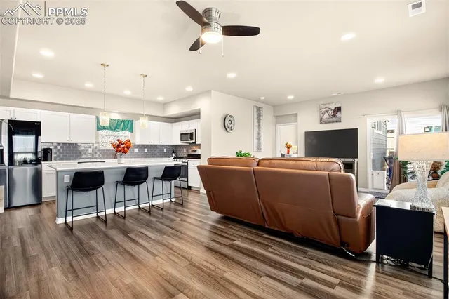 a living room with lots of furniture and kitchen view