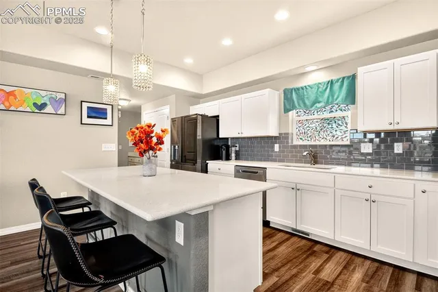 a kitchen with a dining table chairs and white cabinets