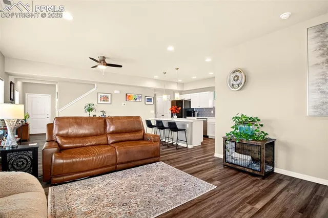 a living room with furniture and a wooden floor