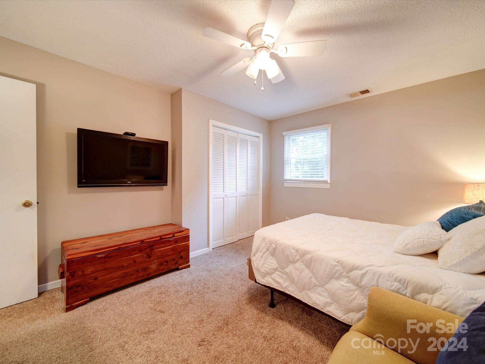 20126 Rainbow Circle Cornelius, NC 28031 - Photo 19 of 40 a bedroom with a bed and a flat screen tv