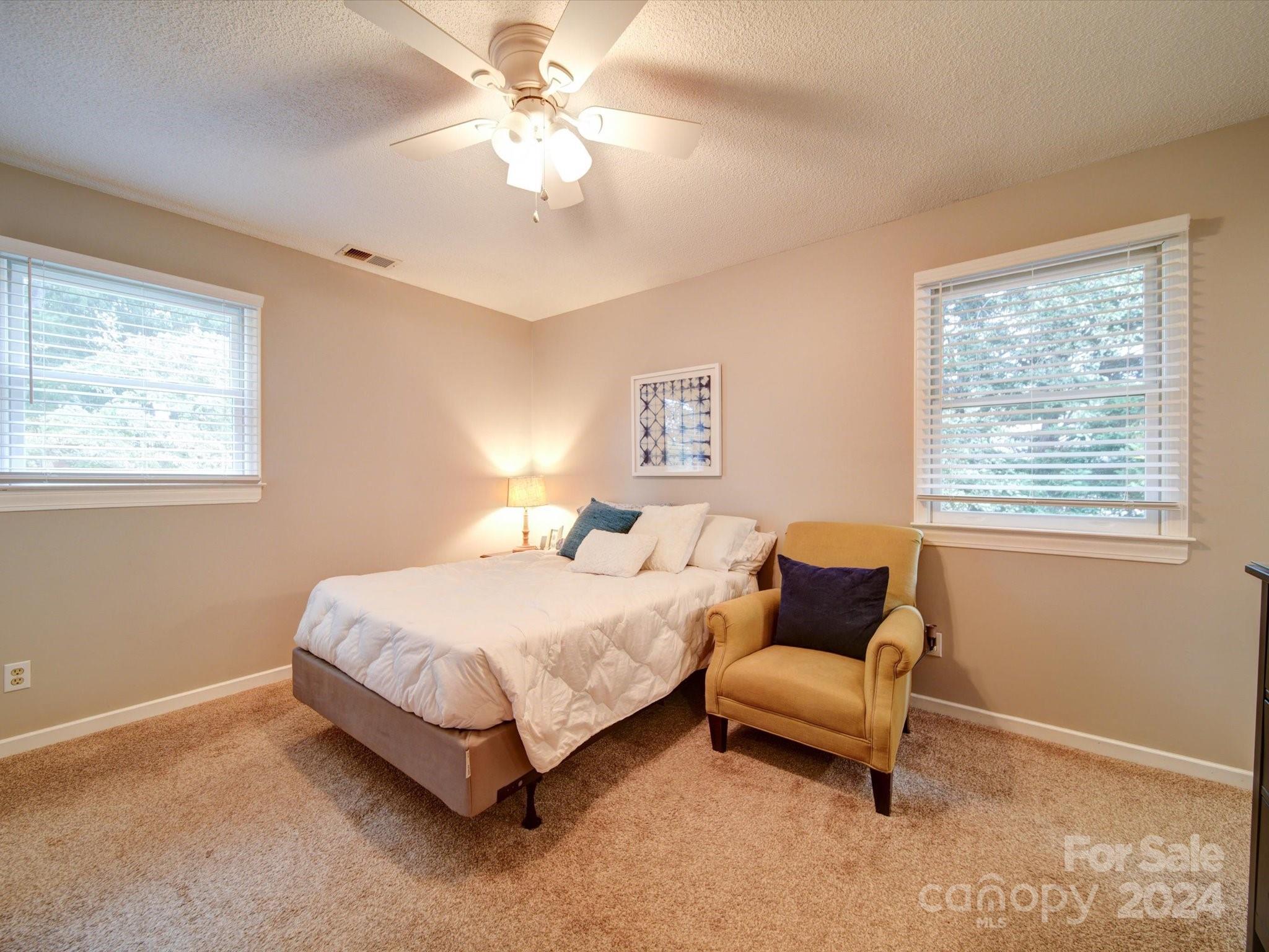 20126 Rainbow Circle Cornelius, NC 28031 - Photo 20 of 40 a spacious bedroom with a bed and a chandelier