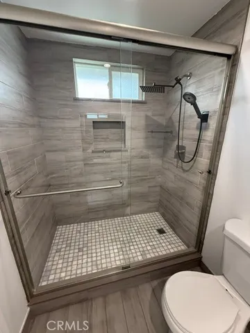 a bathroom with a toilet and a shower