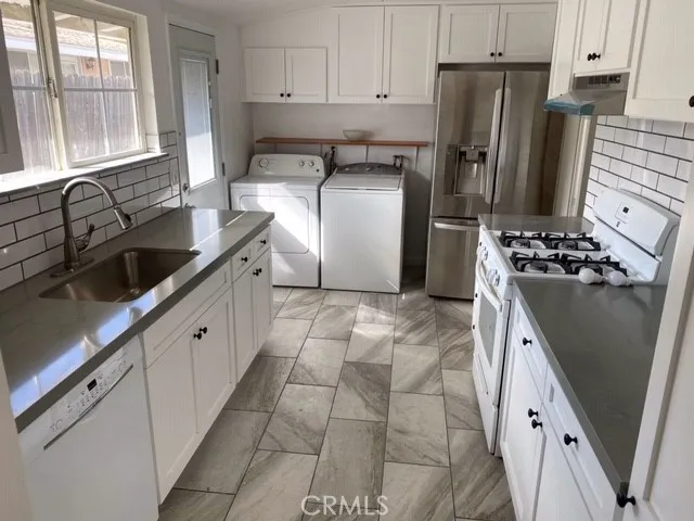 a kitchen with stainless steel appliances a refrigerator sink and stove