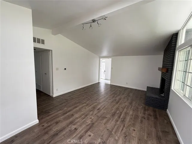a view of a livingroom with wooden floor and staircase