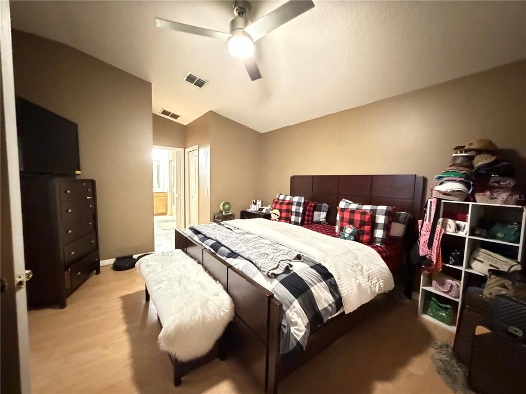 945 Tramells Trail Kissimmee, FL 34744 - Photo 22 of 36 a bedroom with a bed and a flat tv screen