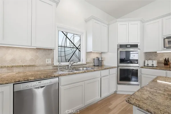 a kitchen with stainless steel appliances granite countertop a sink stove and cabinets