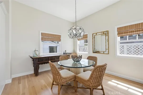 a dining room with furniture a chandelier and wooden floor
