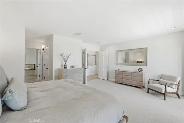 a spacious bedroom with a bed a couch and a view of bedroom