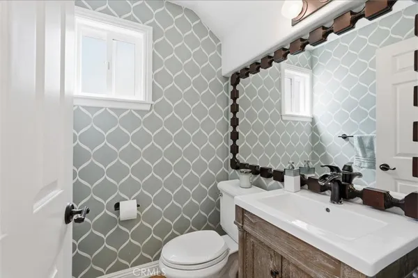 a bathroom with a sink a toilet and a mirror