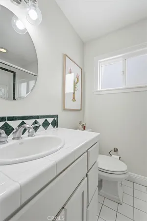 a bathroom with a sink a toilet and mirror