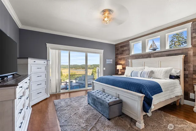 a bedroom with a bed and a flat tv screen on dresser