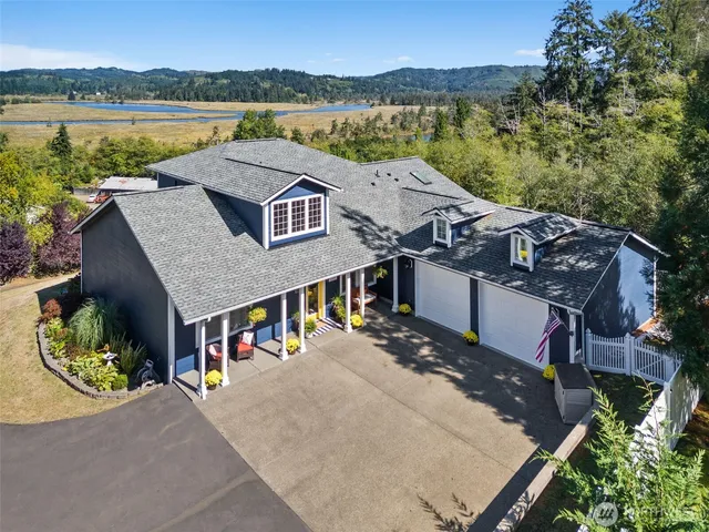 an aerial view of a house with a garden and lake view