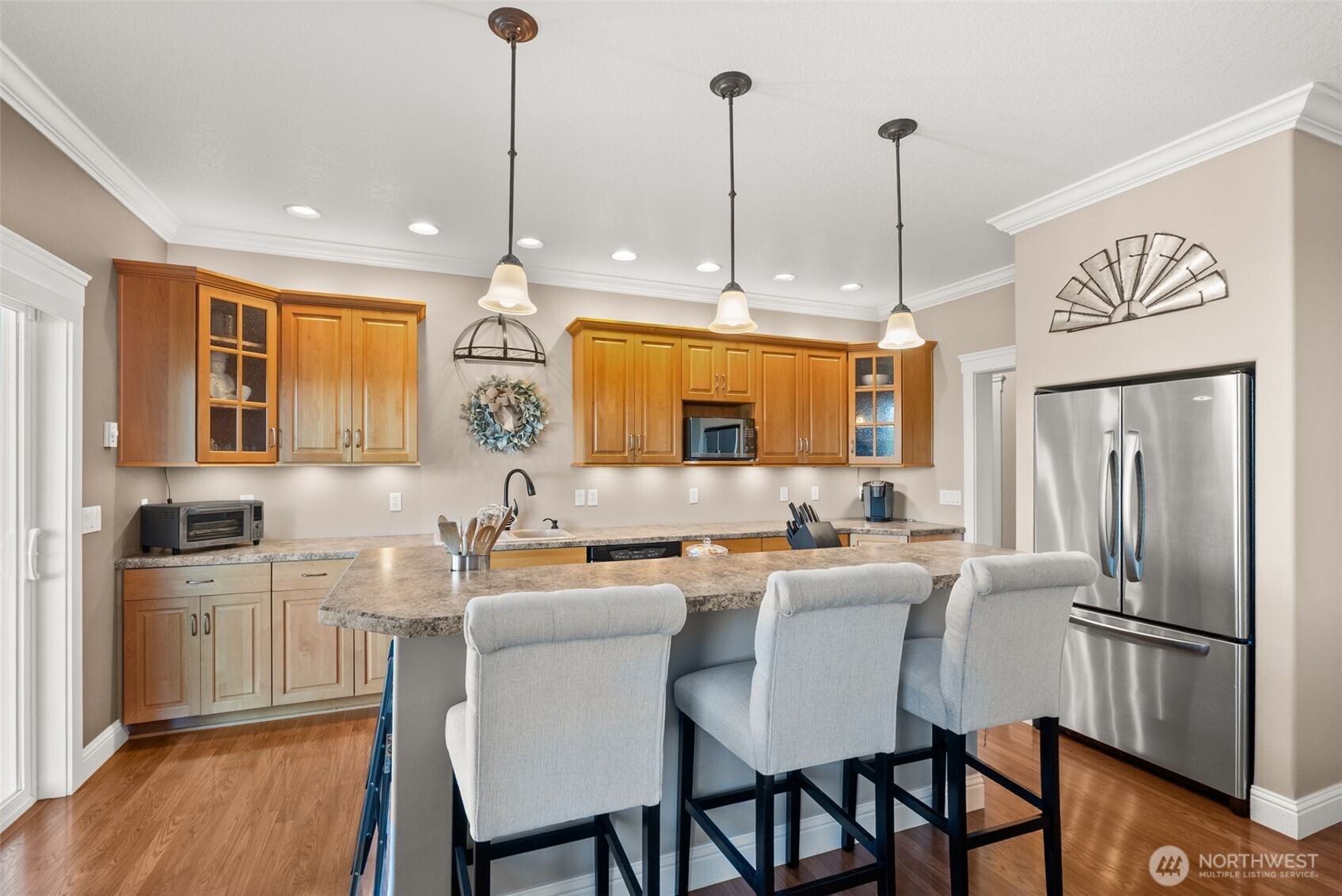 1480 Pacific Avenue Raymond, WA 98577 - Photo 10 of 40 a kitchen with stainless steel appliances granite countertop a sink a stove a refrigerator with island and chairs