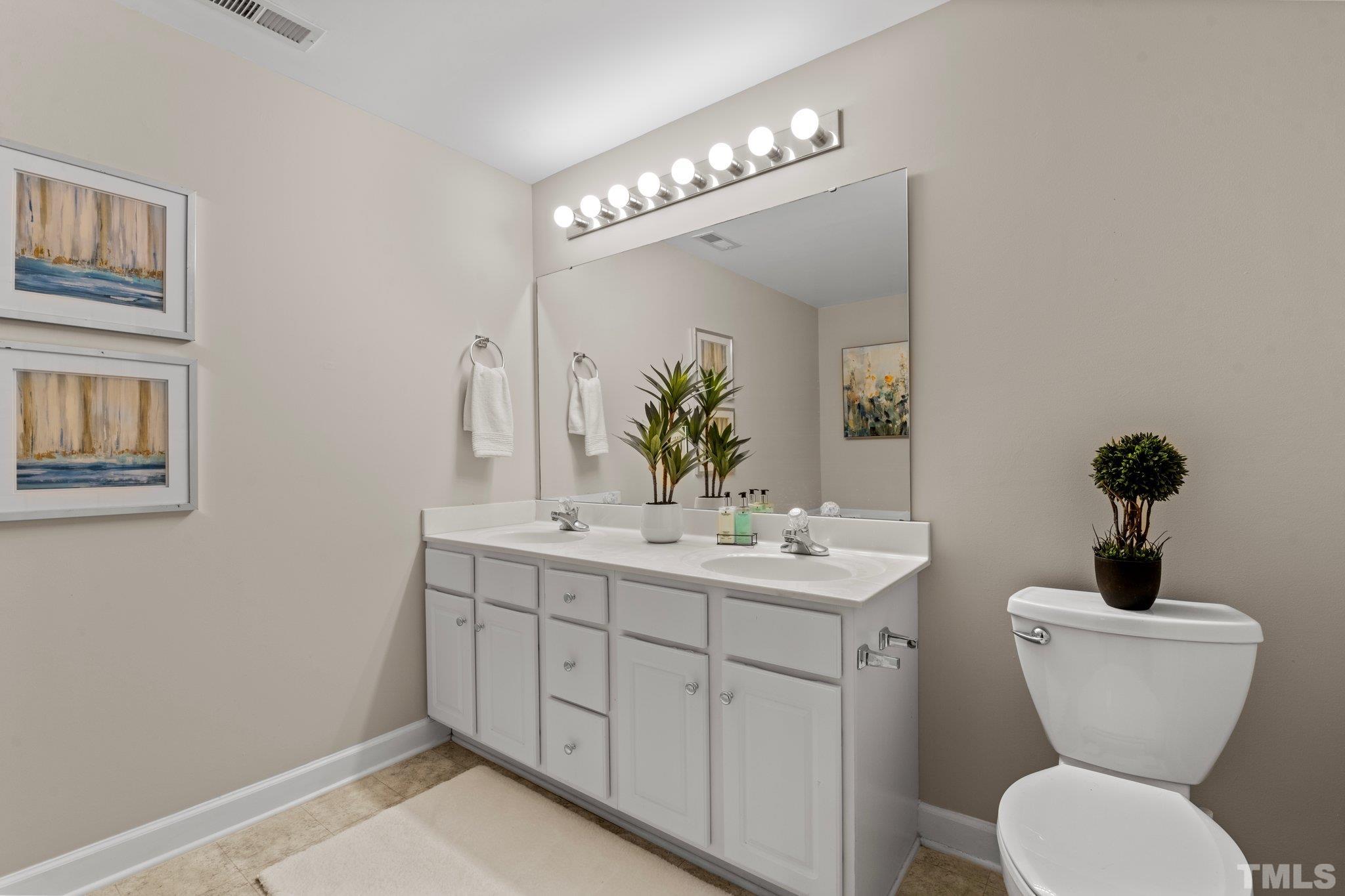 7024 Sandy Forks Road, Unit 302 Raleigh, NC 27615 - Photo 16 of 24 a bathroom with a toilet a sink and mirror