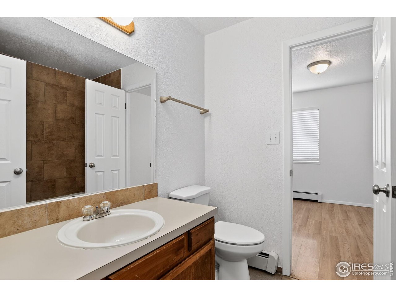 3535 28th Street, Unit 202 Boulder, CO 80301 - Photo 20 of 31 a bathroom with a granite countertop sink toilet a mirror and shower