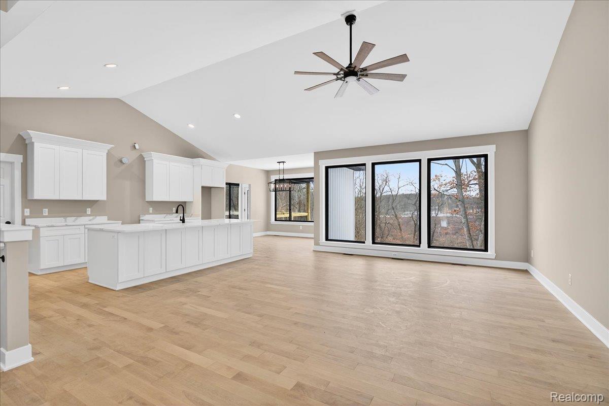 4050 Metamora Ridge Road Metamora, MI 48455 - Photo 29 of 65 Unfurnished living room with light wood-type flooring, a ceiling fan, recessed lighting, and high vaulted ceiling