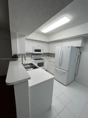 a kitchen with appliances a sink and cabinets