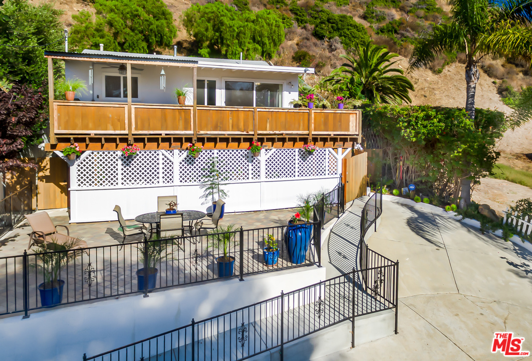 3938 Las Flores Canyon Road Malibu, CA 90265 - Photo 21 of 21 a balcony with table and chairs and potted plants
