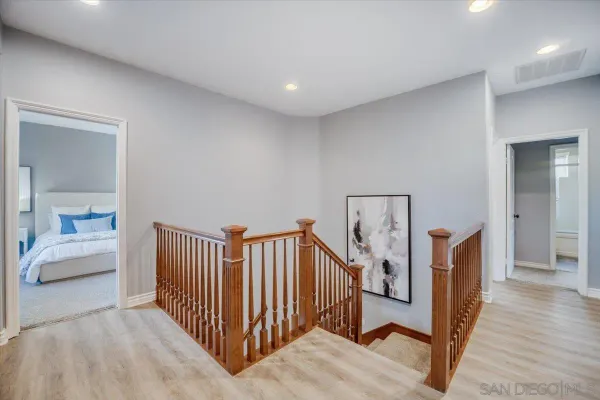 a view of a hallway with a bedroom and windows