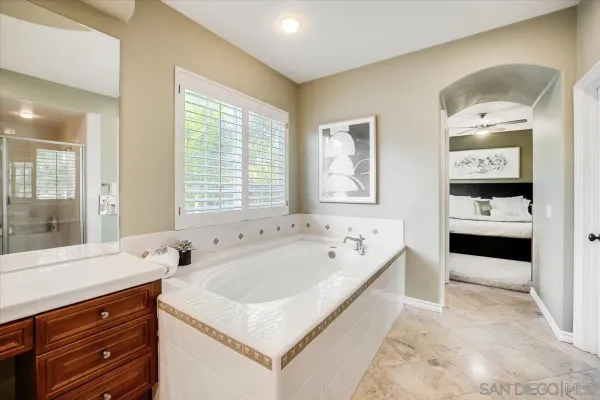 a spacious bathroom with a tub sink and mirror