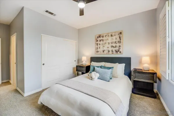 a bedroom with a bed and a ceiling fan
