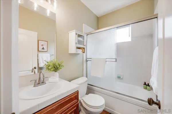 a bathroom with a sink a toilet a tub and shower