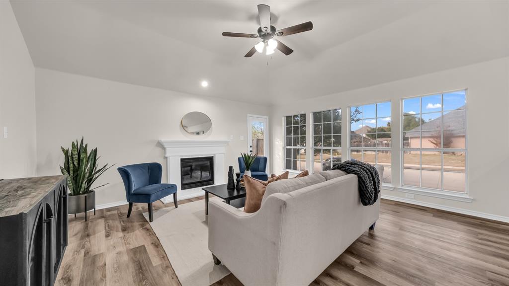 a living room with furniture a fireplace and a floor to ceiling window