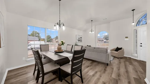 a view of a dining room with furniture wooden floor and chandelier