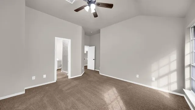 an empty room with chandelier fan