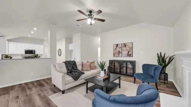 a living room with furniture and a view of kitchen