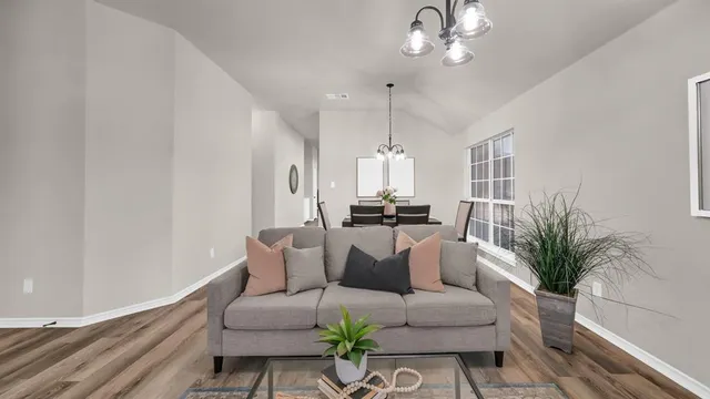 a living room with furniture a chandelier and a potted plant