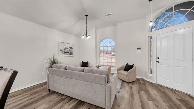a living room with furniture and a chandelier